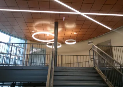 The ceiling of a building with stairs and lights.