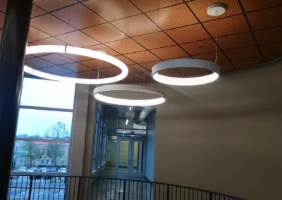Three circular lights hanging from the ceiling of a building.